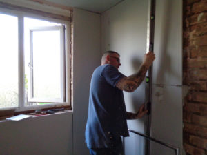 Nuneaton Bathrooms fitting plaster board to a bathroom brick wall